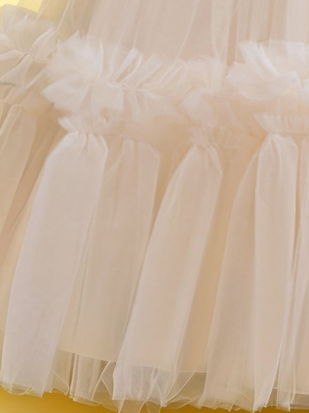 Blisseven champagne girls party dress close-up of the tulle skirt and ruffle accents